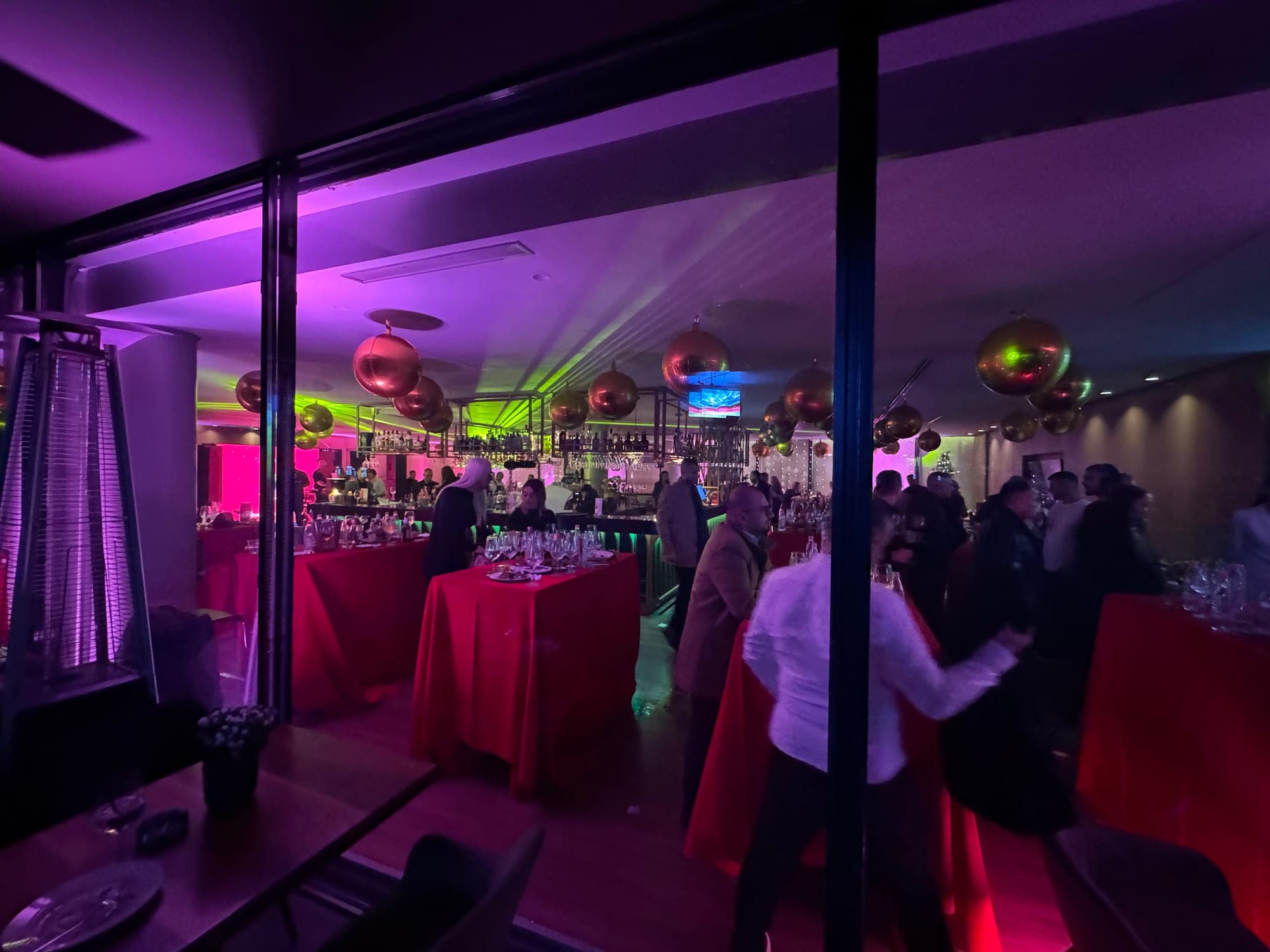 Guests gathered at the bar during an evening event in the red-lit lounge