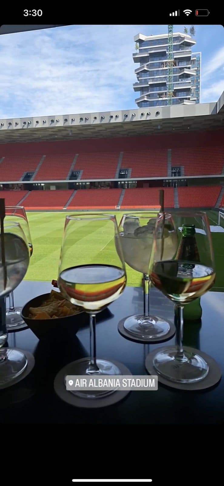 Guest photo of wine glasses on the table with the pitch and city tower behind