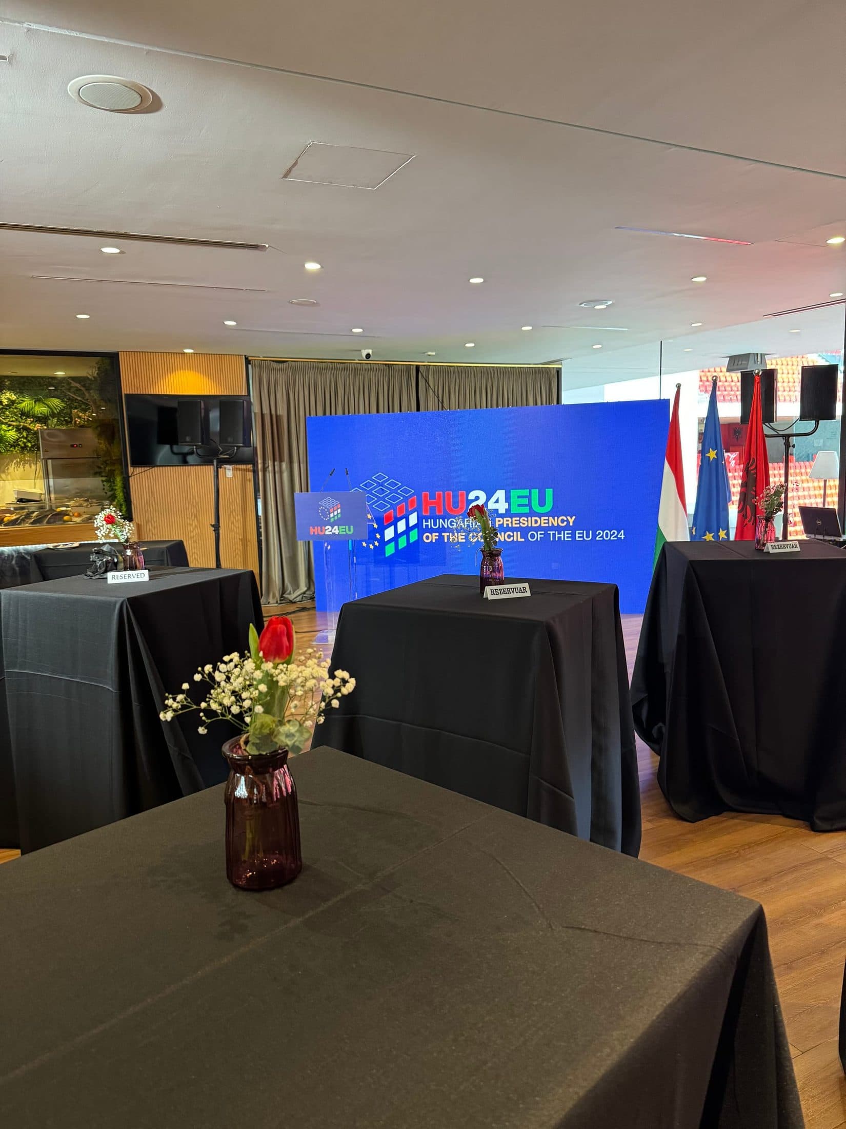 Branded stage backdrop and reception tables set up before guests arrive