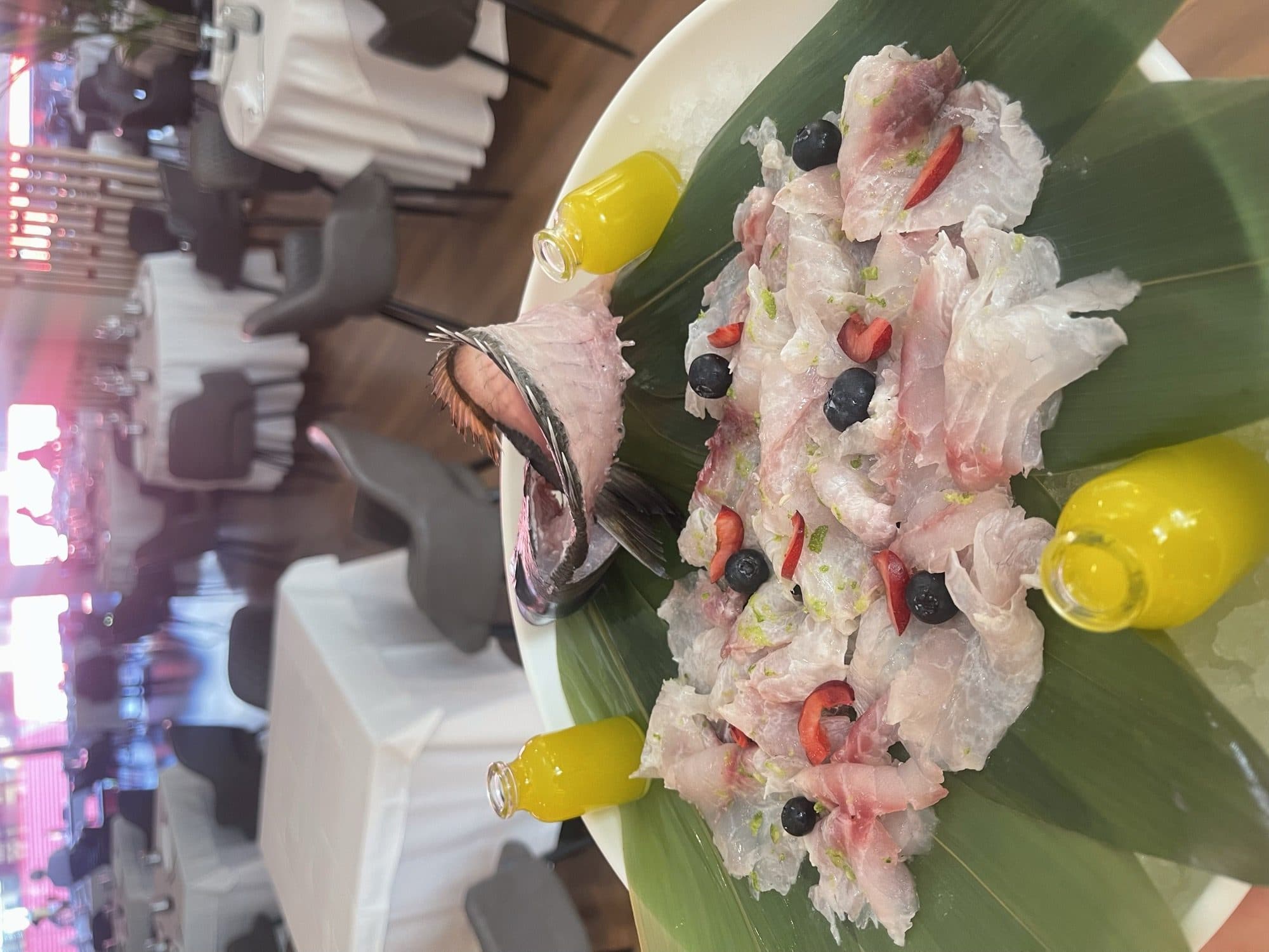 Whole fish crudo with the dining room in the background