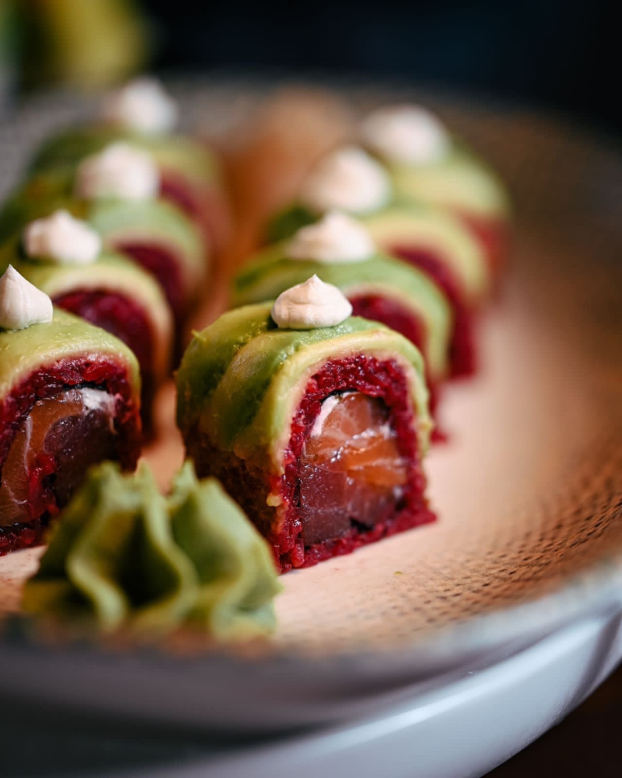 Close-up cross-section of colorful sushi rolls with a wasabi swirl and pickled ginger