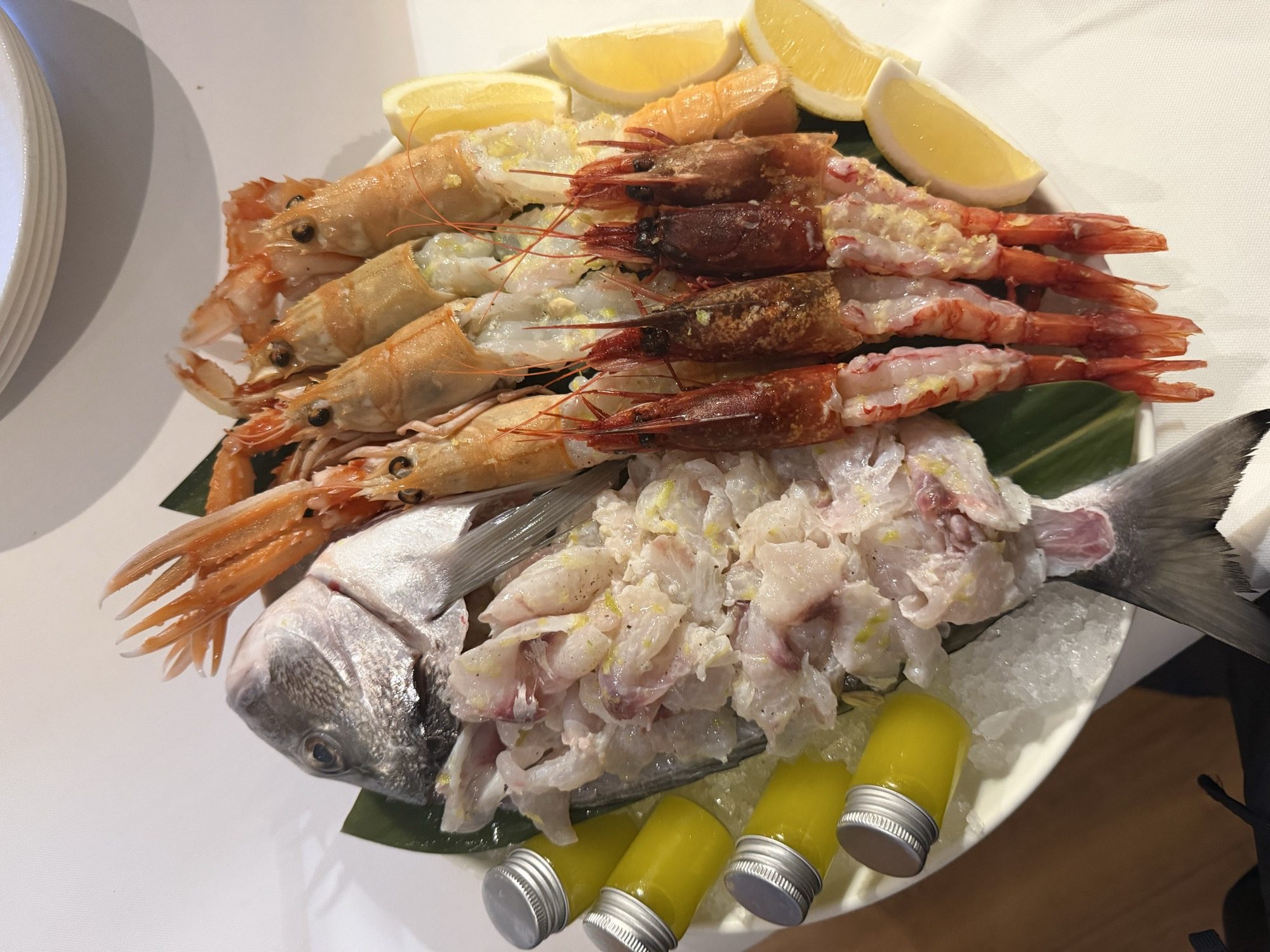 Whole fish and grilled prawns served on ice