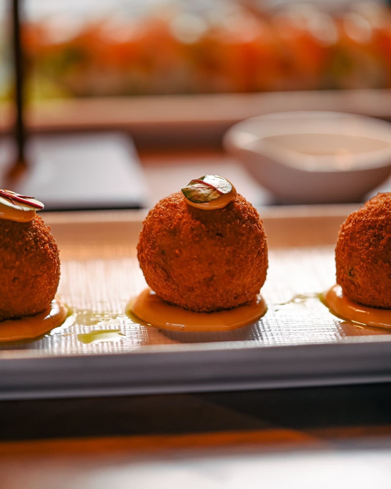 Fried appetizer bites plated with a citrus dressing