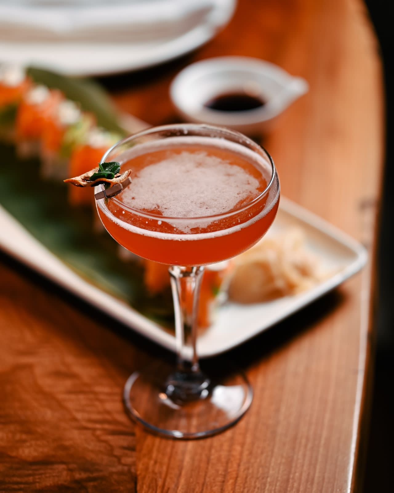 A pink cocktail served on a plate at the table